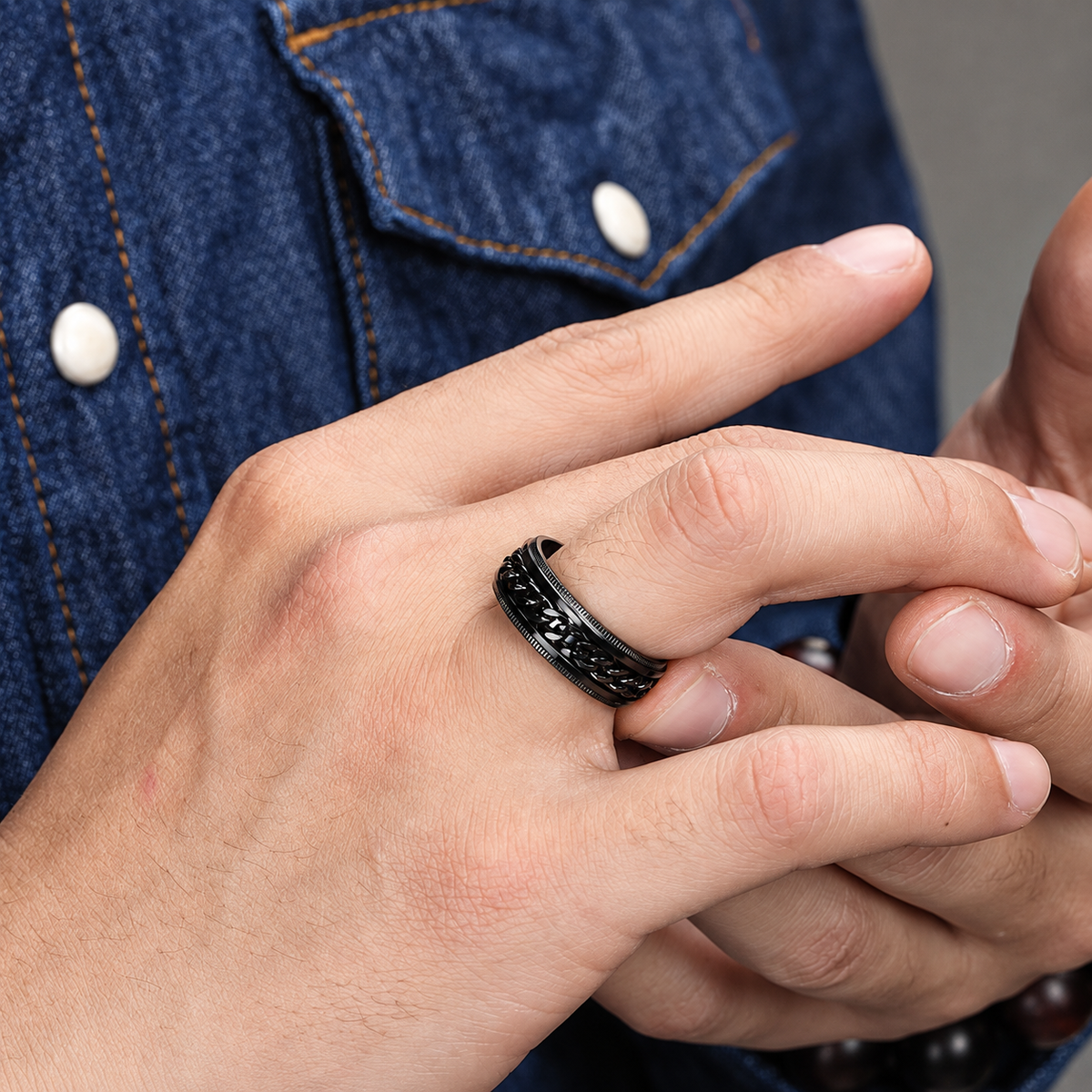 Bague anti-stress anneau tournant Blackchaîne, chaîne gourmette tournante sur bague noire aux bords crantés, portée au doigt