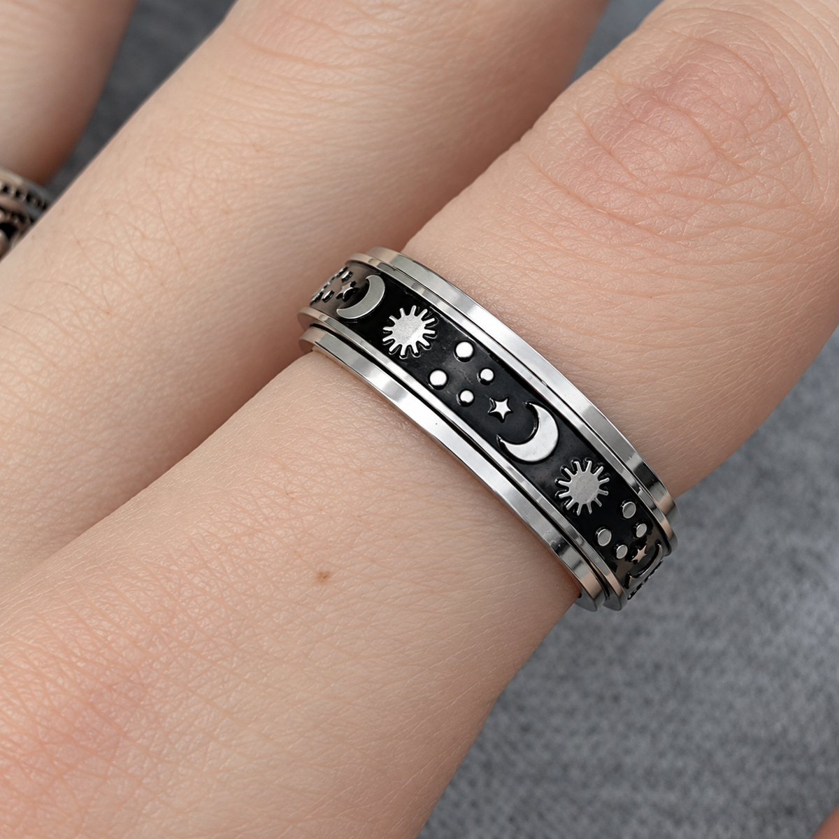 Bague anti-stress anneau tournant Soleil Luné, anneau tournant noir orné de soleils, lunes et étoiles argentés, portée au doigt