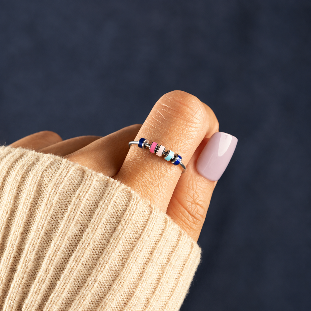 Bague anti-stress bille Colorée, jonc ouvert à rondelles émaillées pastel, portée au doigt