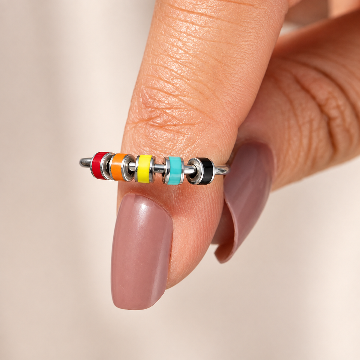 Bague anti-stress bille Colorée, jonc ouvert à rondelles émaillées pastel, portée au doigt