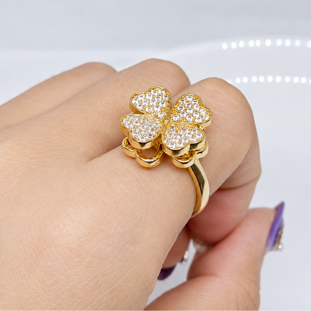 Bague anti-stress rotative Cœur Florale dorée, fleur de quatre cœurs pavés de petites pierres, portée au doigt