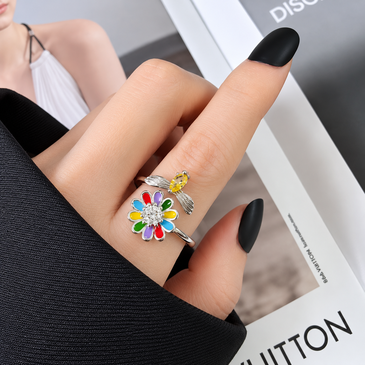 Bague anti-stress rotative Douce Butine, fleur émaillée multicolore et abeille à pierre jaune, portée au doigt