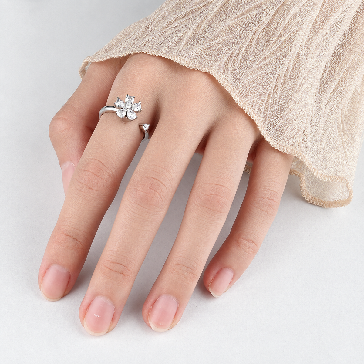 Bague anti-stress rotative Fleur Cristal argentée, fleur aux pétales de cristal en forme de goutte, portée au doigt