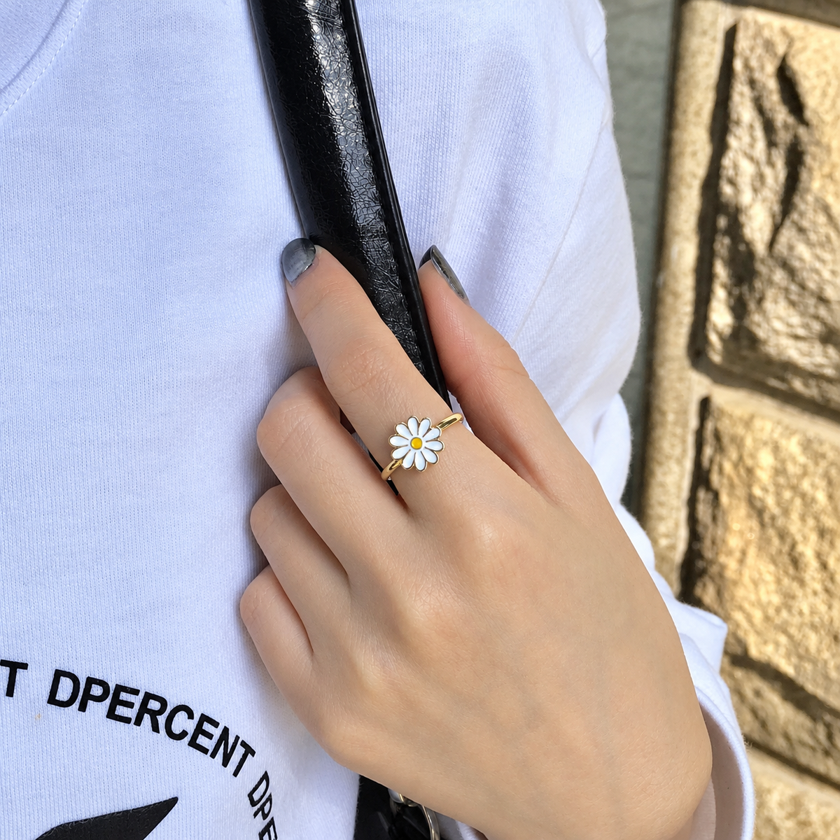 Bague anti-stress rotative Marguerite, marguerite émaillée blanche au cœur orangé, portée au doigt