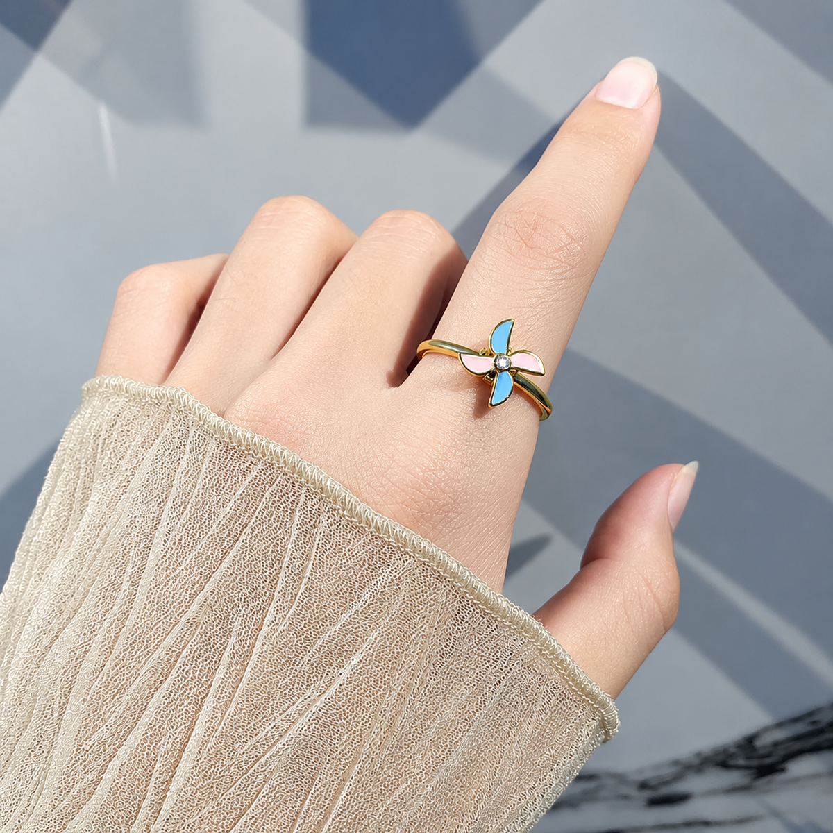Bague anti-stress rotative Moulin, moulin à vent aux pales émaillées rose et turquoise, portée au doigt