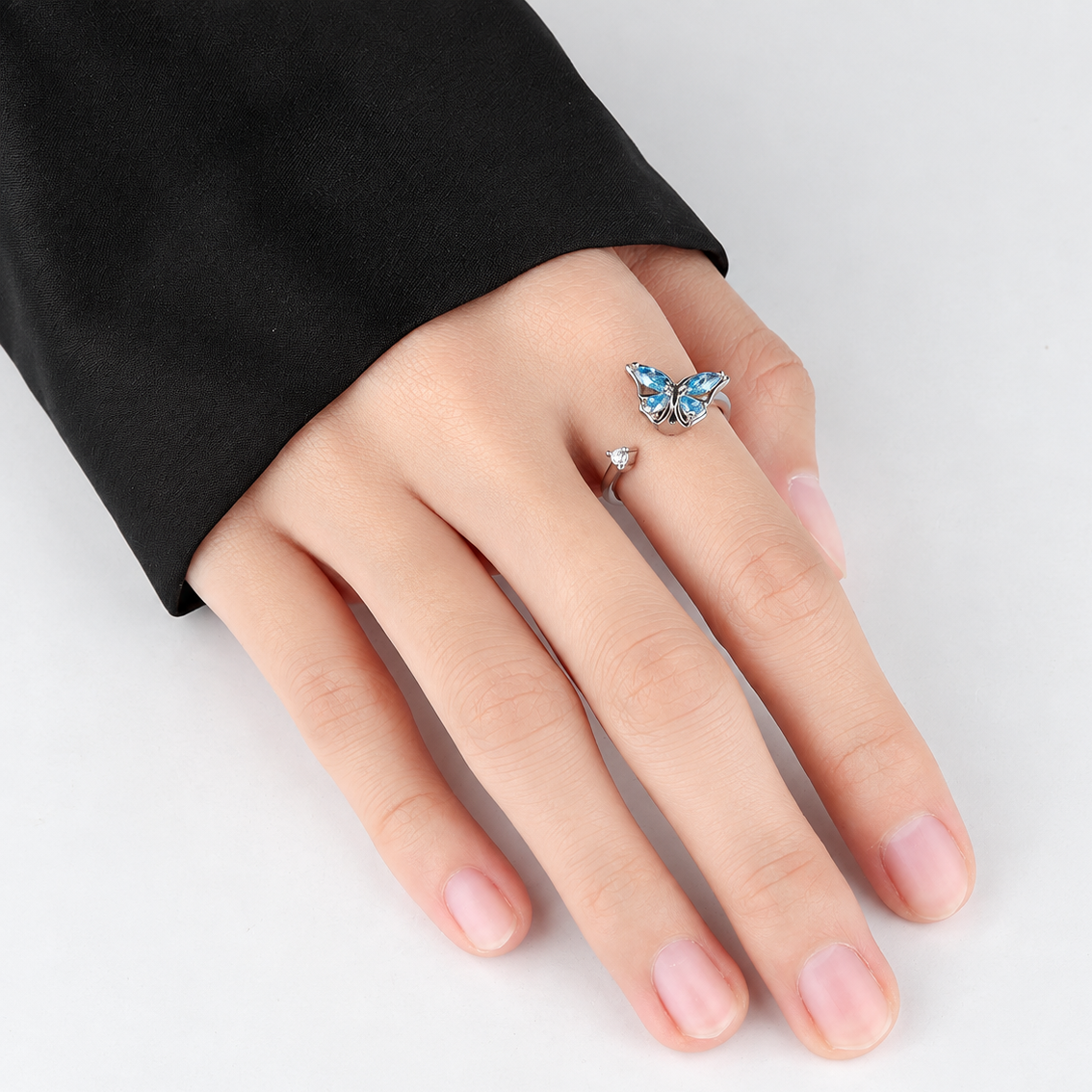 Bague anti-stress rotative Papillon Luisant argentée, papillon aux ailes de pierres bleu ciel taille marquise, portée au doigt