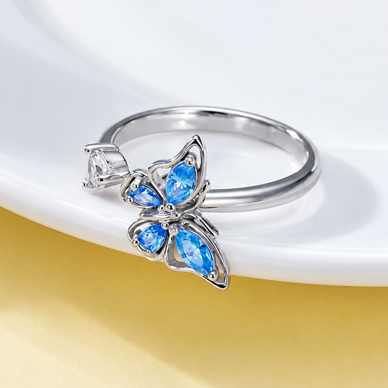 Bague anti-stress rotative Papillon Luisant argentée, papillon aux ailes de pierres bleu ciel taille marquise