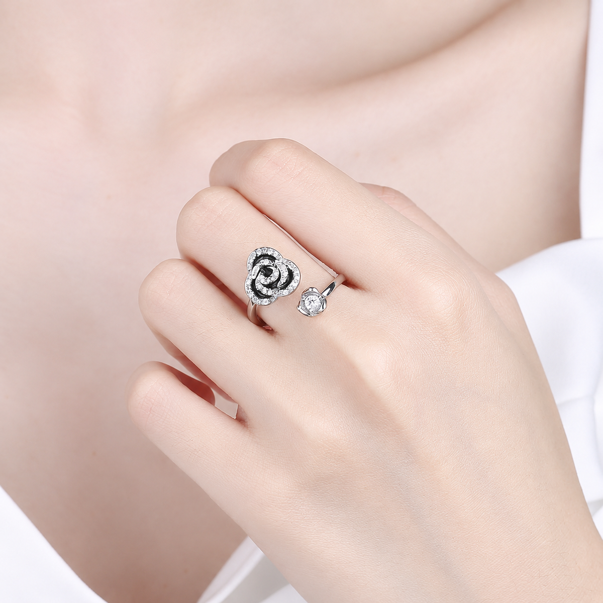 Bague anti-stress rotative Rose, rose en émail noir ourlée de petites pierres, cœur serti, portée au doigt