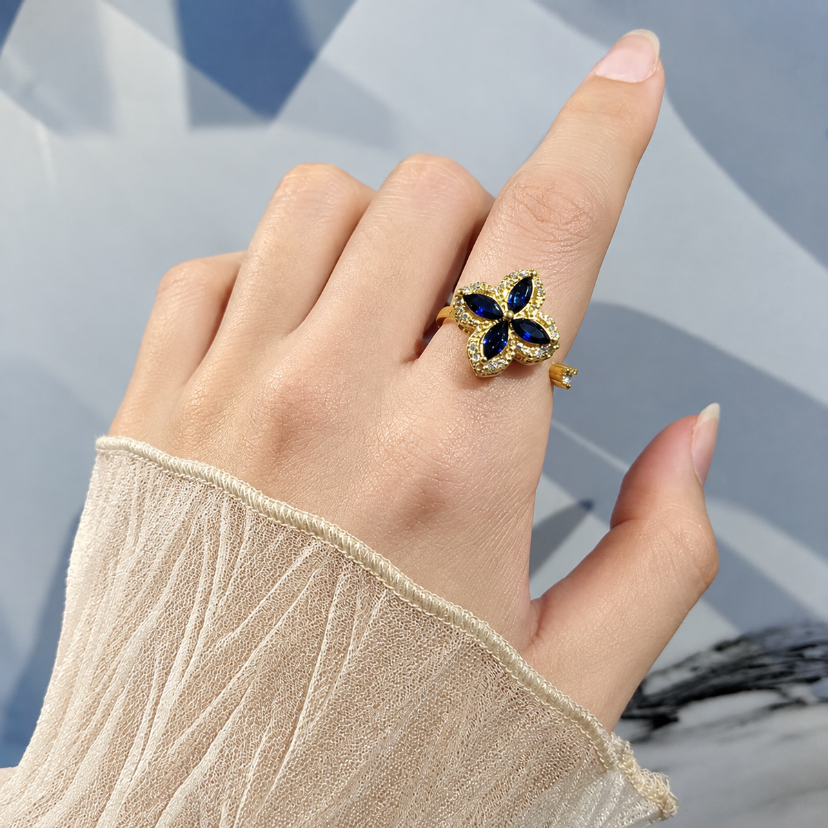 Bague anti-stress rotative Trèfle Galactique dorée, trèfle en pierres bleu nuit taille marquise, bordure pavée, portée au doigt