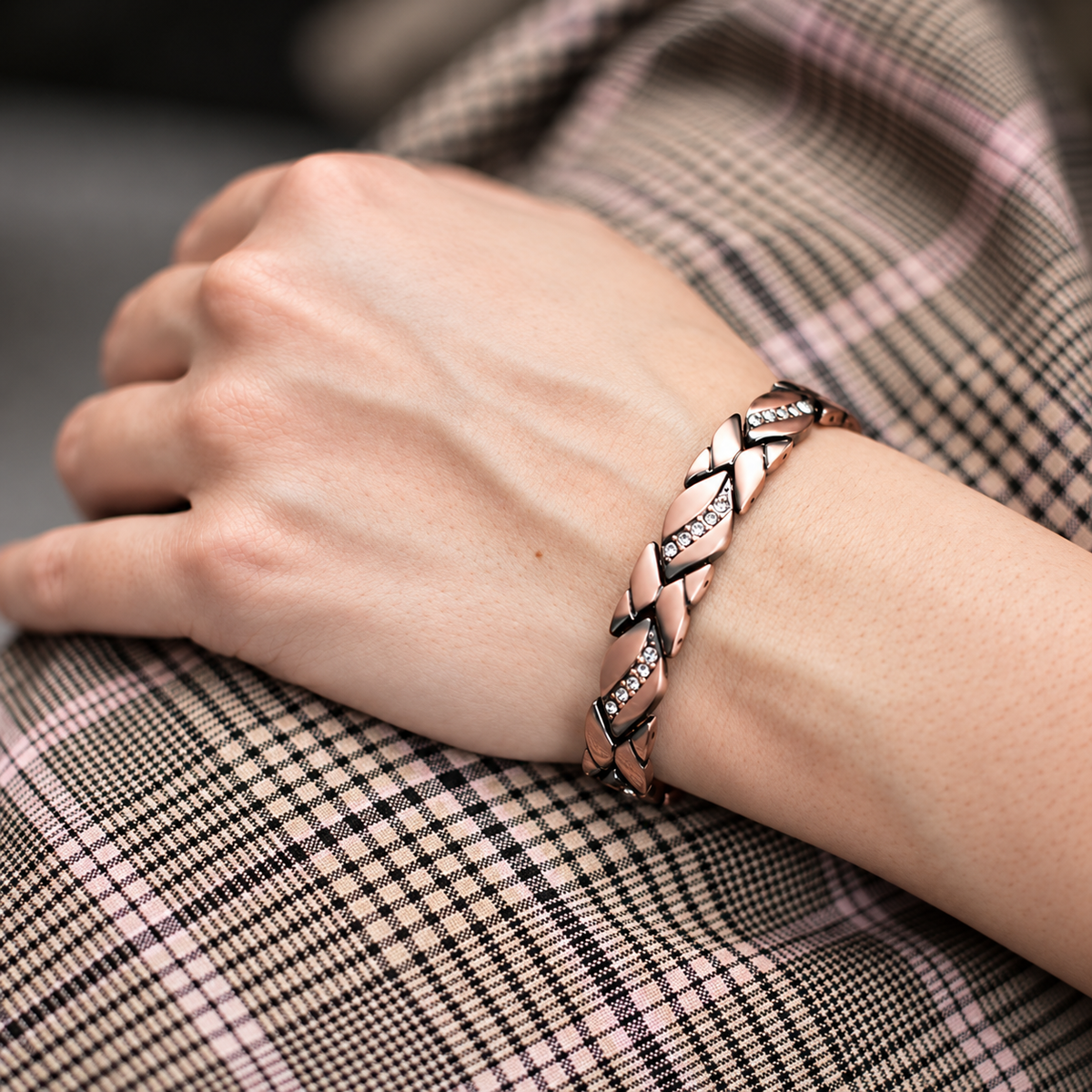 Bracelet magnétique Coquis, maillons en cuivre en X rehaussés de cristaux, porté au poignet