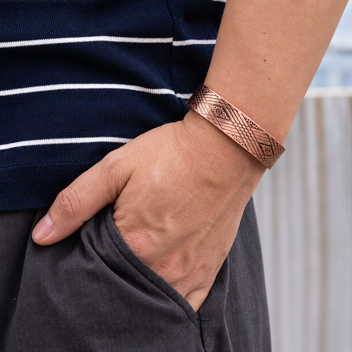 Bracelet magnétique Elise, jonc ouvert en cuivre gravé de losanges et de lignes croisées, porté au poignet