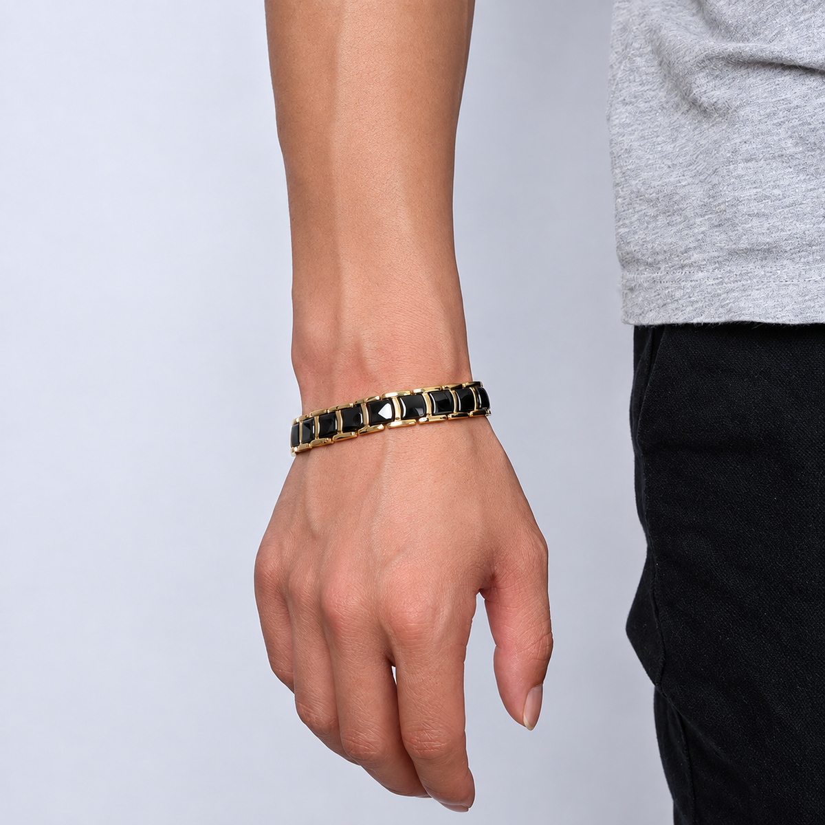 Bracelet magnétique Quilus, maillons dorés incrustés de plaques noires, porté au poignet